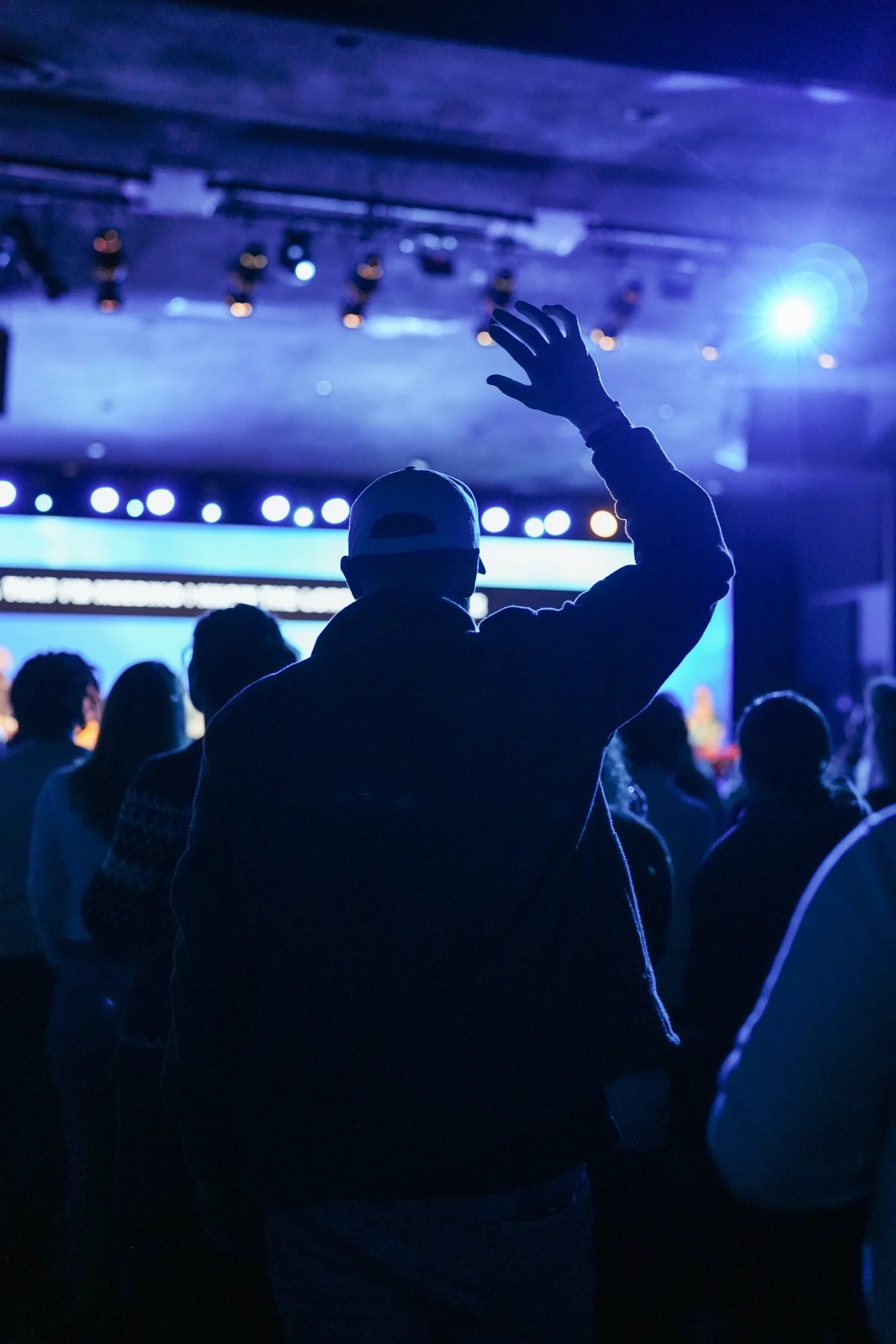 A member of the CenterPoint community raising a hand in worship